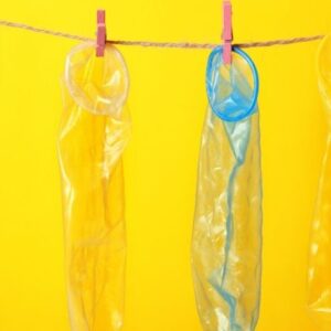 Condoms Hanging on Rope against Yellow Background