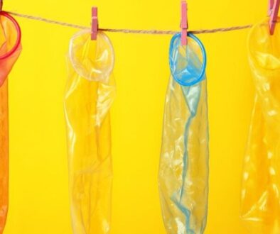 Condoms Hanging on Rope against Yellow Background